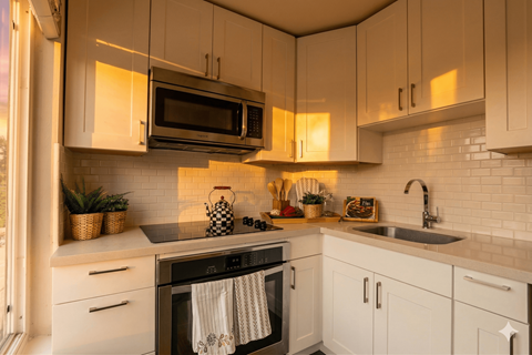 A kitchen with white cabinets and a black stove top oven.