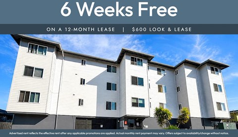 A modern apartment building advertises a 6 weeks free offer on a 12-month lease.