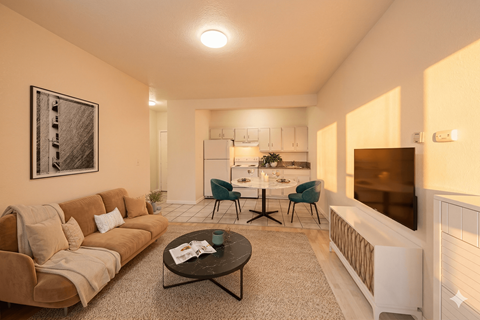 A living room with a couch, coffee table, and a dining table set up in the background.