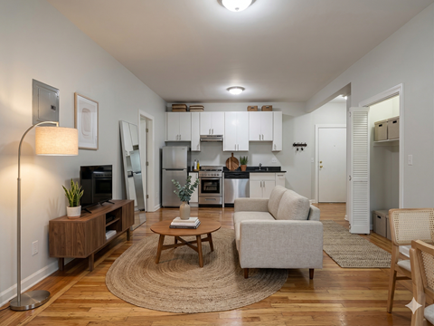 A well-lit, modern living room with a wooden floor and furniture.