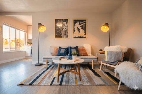 A living room with a white couch, a coffee table, and two lamps.