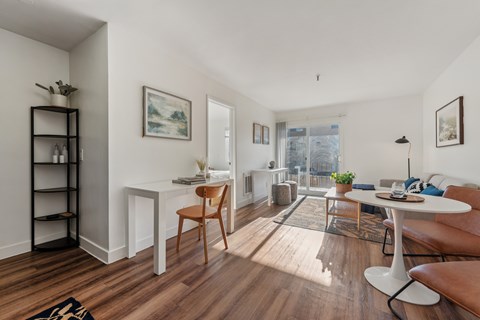 A living room with a white table and a brown chair.