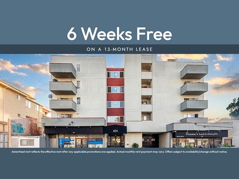 A building with a sign that says "6 Weeks Free on a 13-month lease" in front of it.