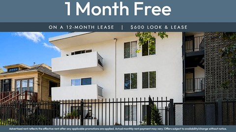 A white building with a black fence and a sign that says "1 Month Free on a 12-month lease | $600 look & lease".