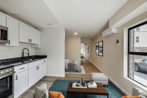 A modern kitchen with white cabinets and a black countertop.