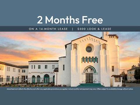 A white building with a large arched doorway and a sign offering 2 months free on a 14-month lease.