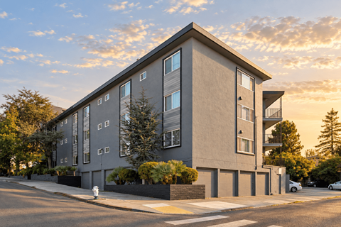 A modern apartment building with a parking lot in front.