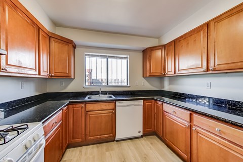 A kitchen with wooden cabinets and a white dishwasher.