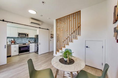 A modern kitchen with a dining table and chairs.