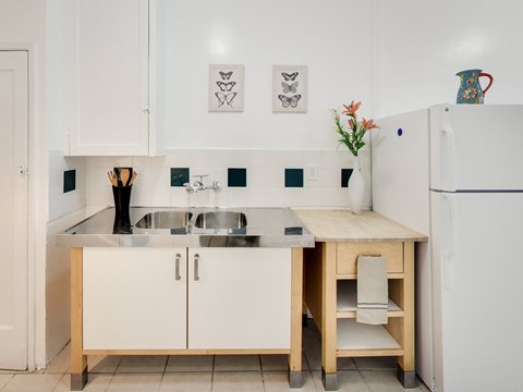 A kitchen with white cabinets and a white fridge.