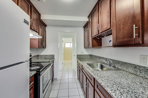A kitchen with brown cabinets and a white fridge.