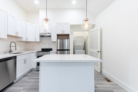 A kitchen with white cabinets and a large island.