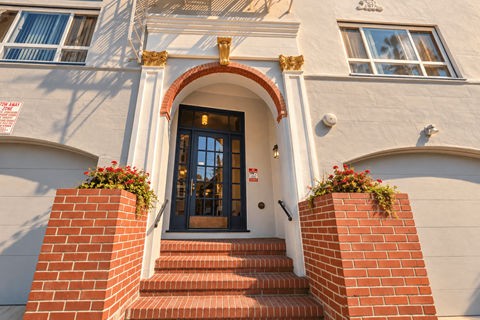 A building with a black door and steps leading up to it.