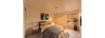A bedroom with a bed, a lamp, a painting, and a potted plant.