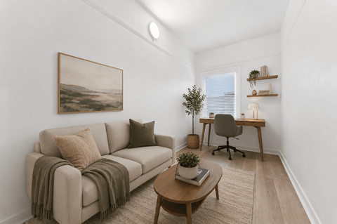 A living room with a couch, a chair, a table, and a painting on the wall.