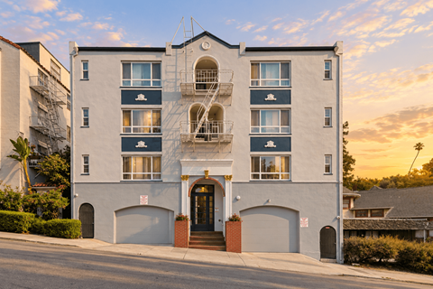 A white building with a blue stripe and a fire escape.