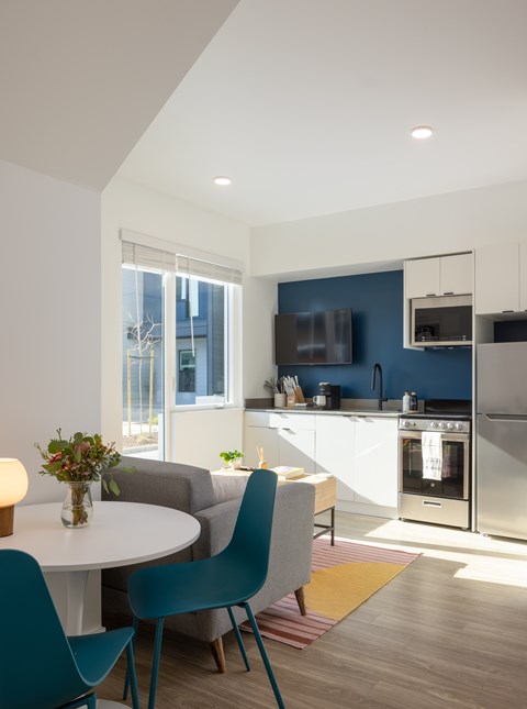 A modern kitchen with a dining table and chairs.