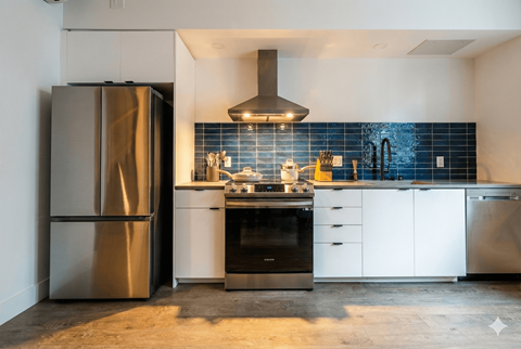 A modern kitchen with a stainless steel refrigerator and a black oven.