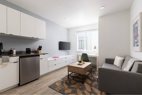 A modern kitchen with a grey couch and a coffee table.