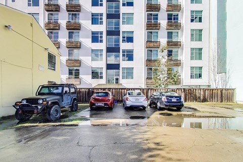 A black jeep is parked in front of a yellow building.