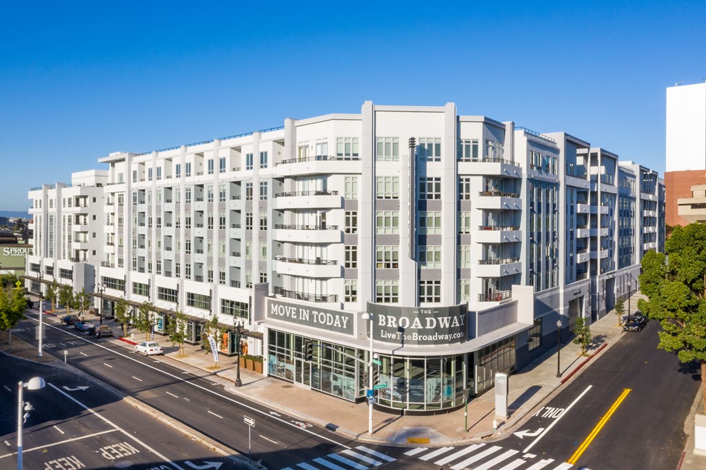 a large white building with a sign on it on a city street