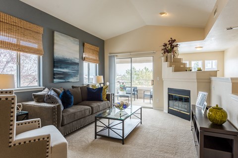 A living room with a couch, chairs, and a fireplace.