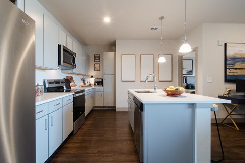 a kitchen with a large island and a stainless steel refrigerator at Parkside at Littleton Village, Littleton, CO