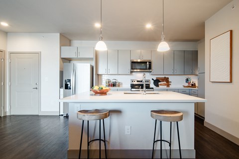 a kitchen with two stools in front of a counter top at Parkside at Littleton Village, Littleton