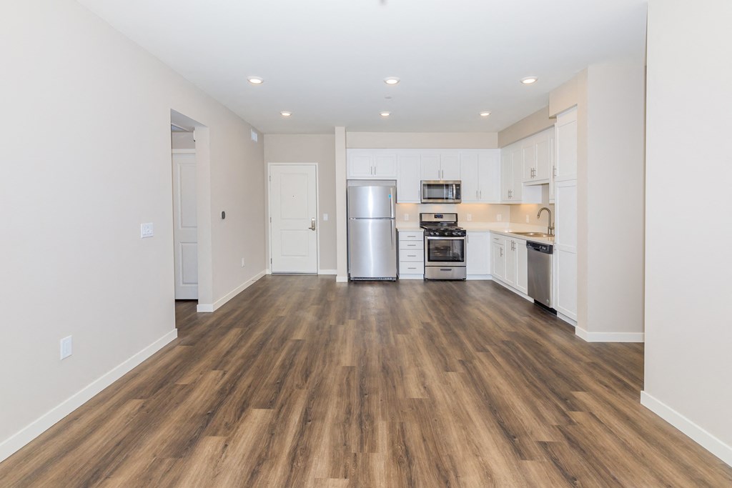 a kitchen with white cabinets and a stainless steel refrigerator