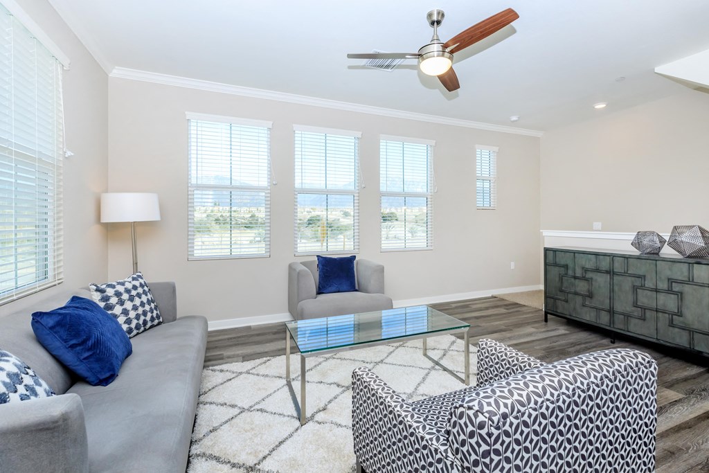 a living room with couches and a glass coffee table