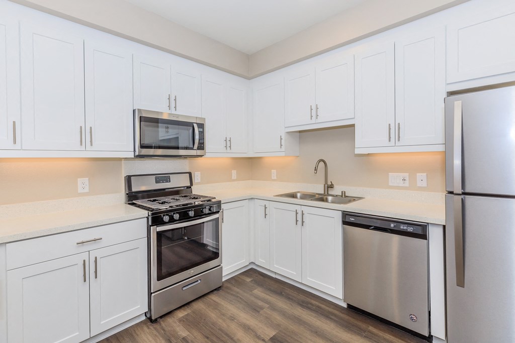 a kitchen with white cabinets and stainless steel appliances