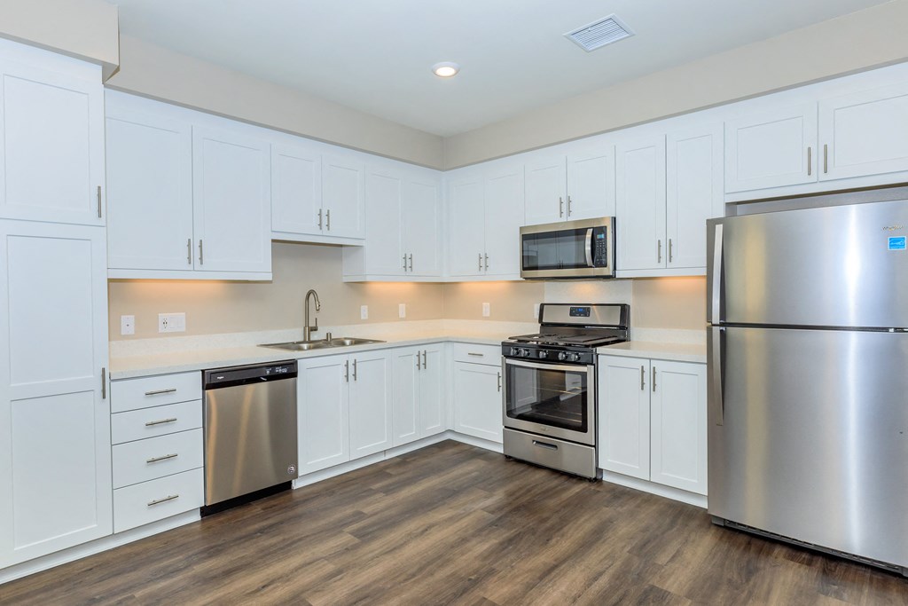a kitchen with white cabinets and stainless steel appliances