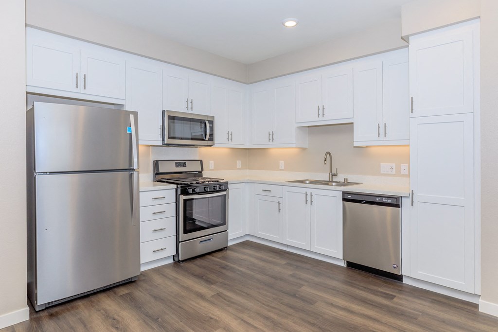 a kitchen with white cabinets and stainless steel appliances