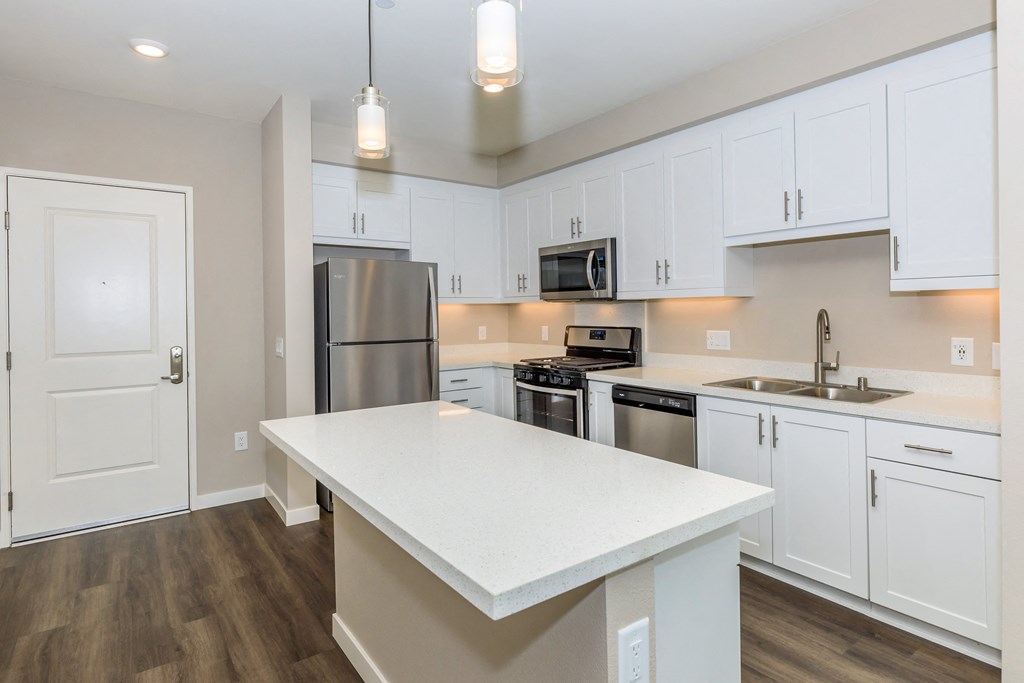 a kitchen with white cabinets and stainless steel appliances