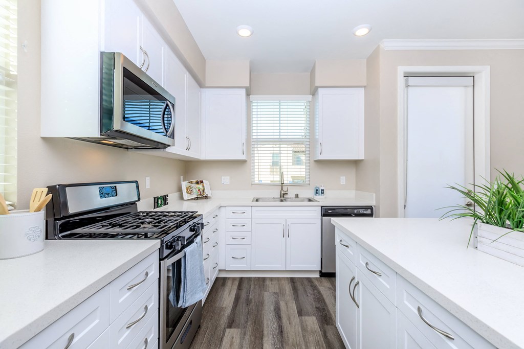 a kitchen with white cabinets and a stove and a microwave
