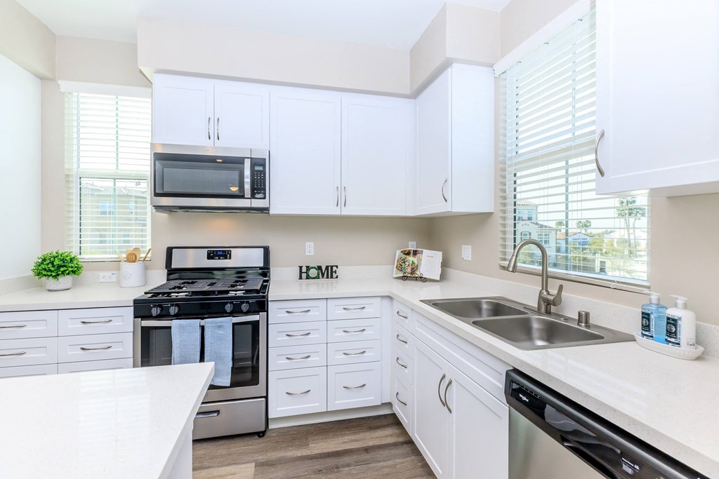 a kitchen with white cabinets and stainless steel appliances