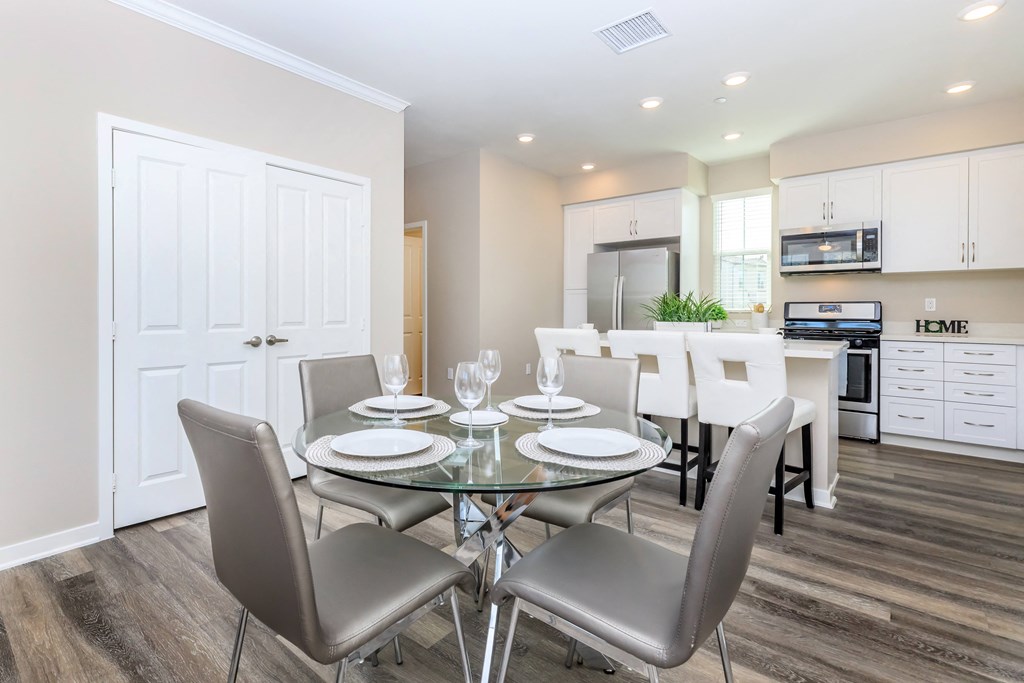 a dining room with a glass table and chairs