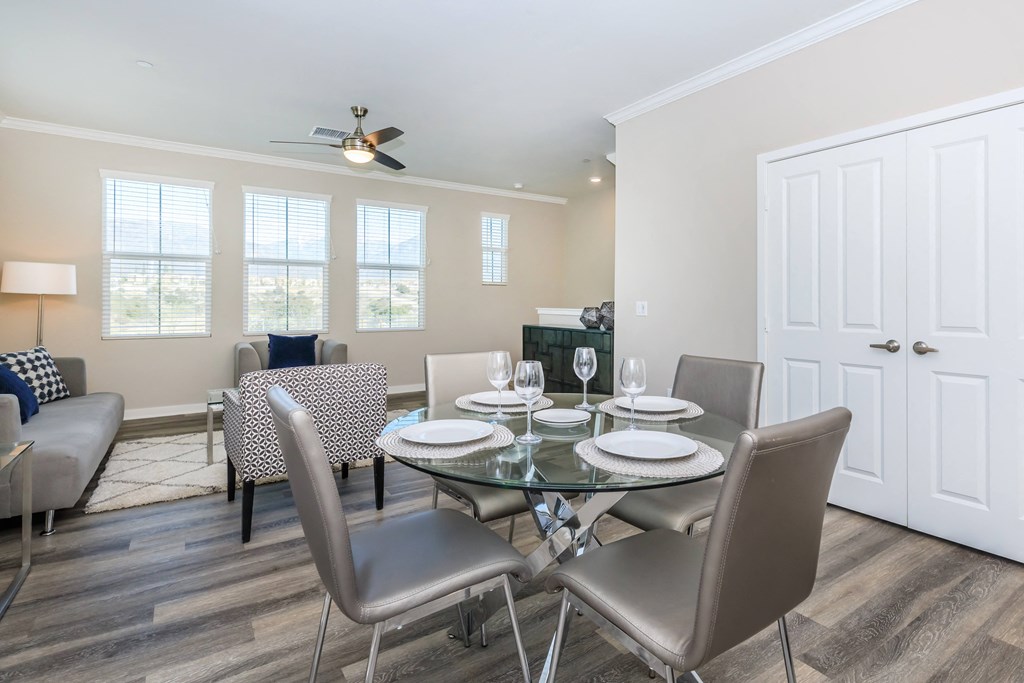 a dining room with a glass table and chairs
