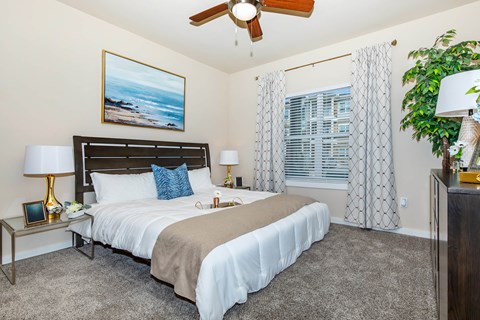 A bedroom with a large bed and a ceiling fan.