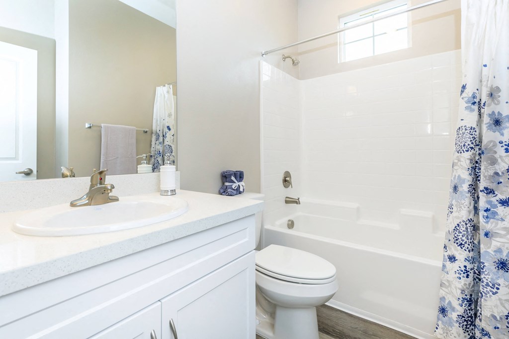 a white bathroom with a shower and a sink and a toilet