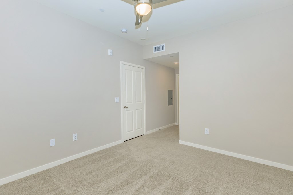 a empty room with a white door and a ceiling fan