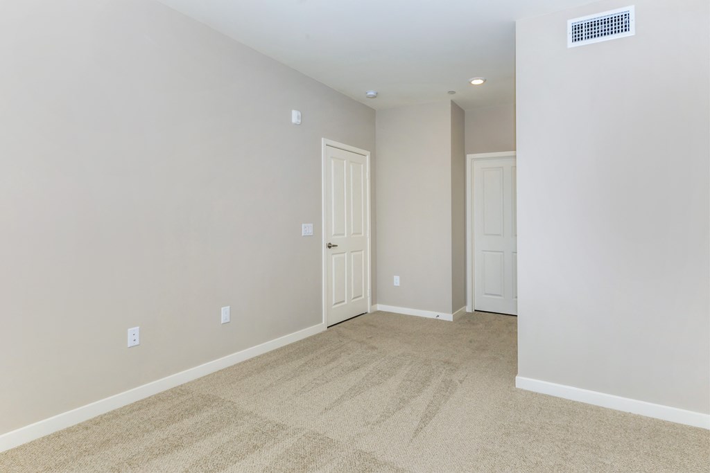 a room with a carpeted floor and a white door