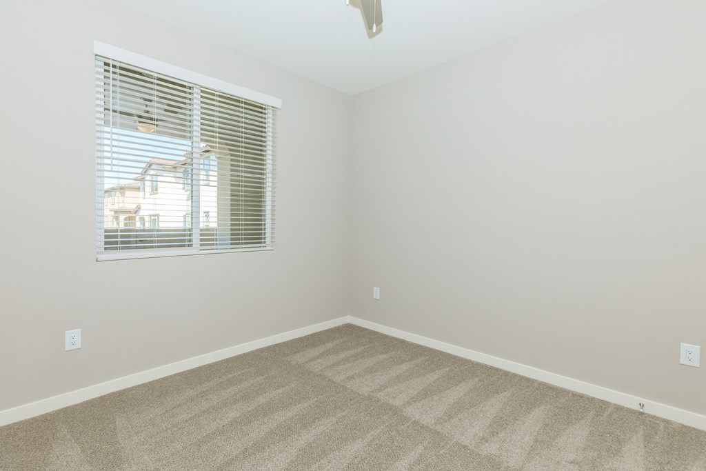 an empty room with a window and a carpet