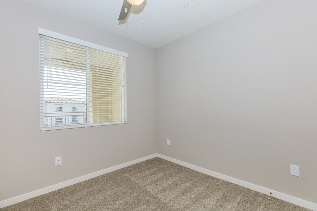 an empty room with a window and a carpet