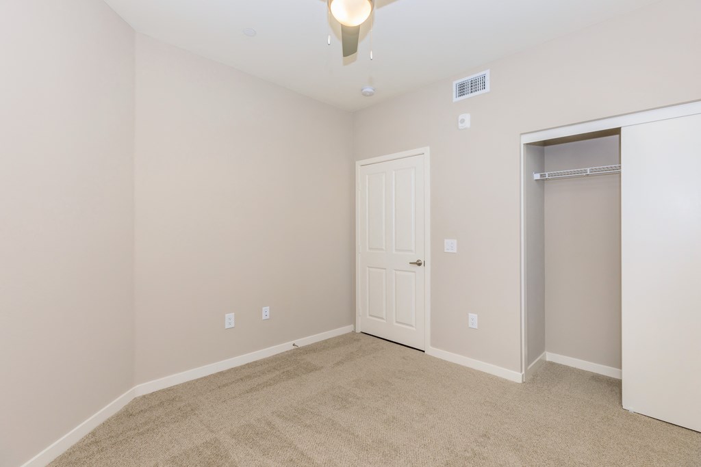 a empty room with a closet and a door to a bathroom