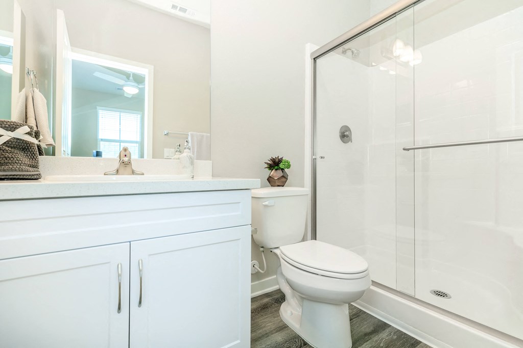 a white bathroom with a shower and a toilet
