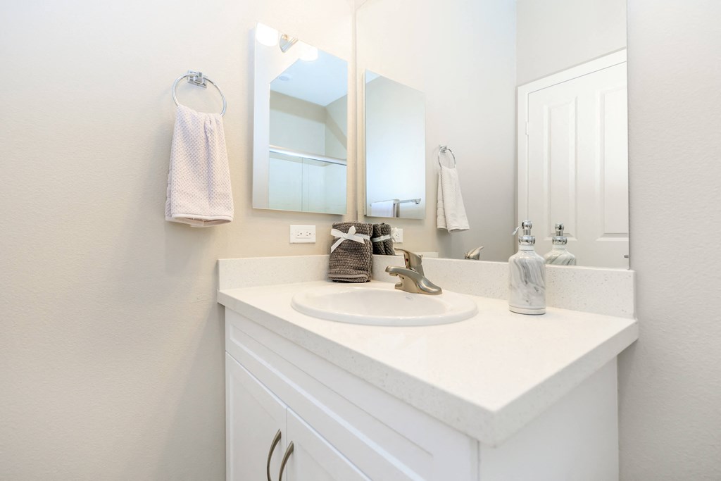a white bathroom with a sink and a mirror