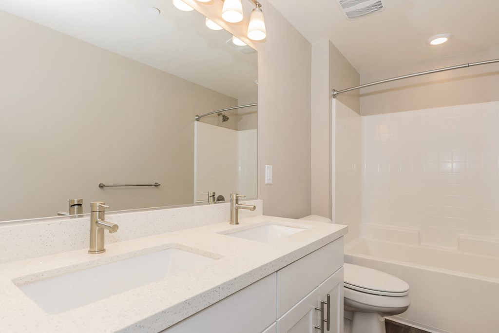 a bathroom with two sinks and a toilet and a shower