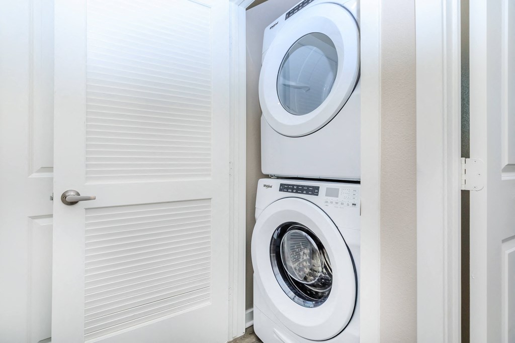 a white washer and dryer in a laundry room with a door