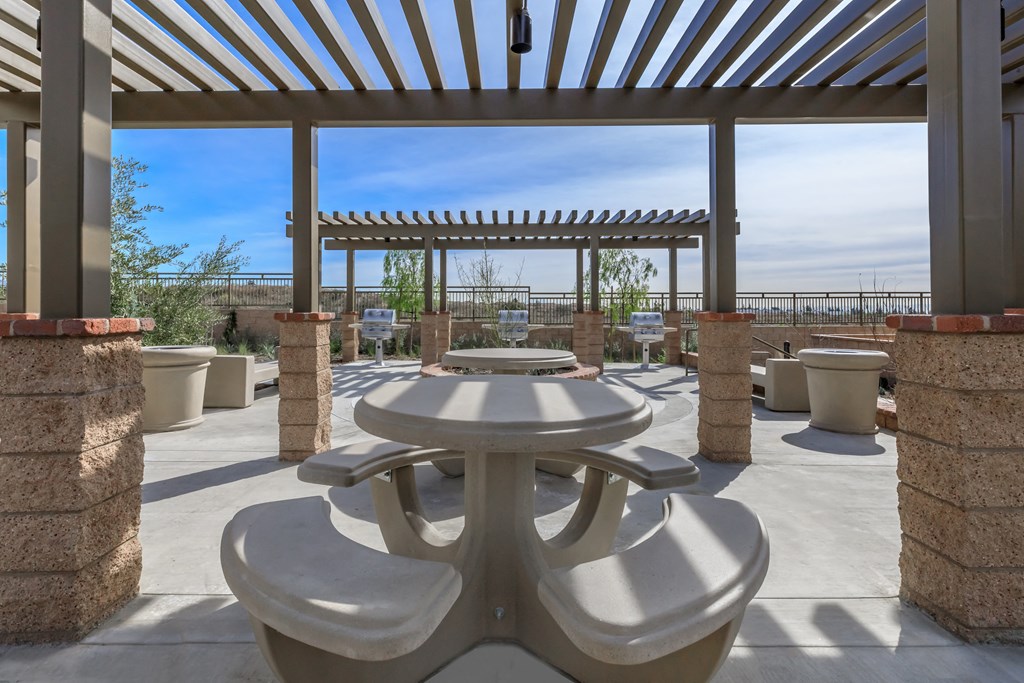 a patio with tables and chairs and a pergola